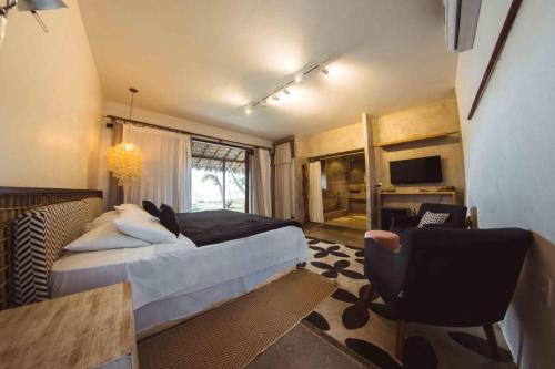 een slaapkamer met een bed, een bureau en een stoel bij Hotel Boutique Zebra Beach in Uruau