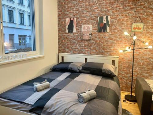 a bed in a room with a brick wall at Premium Apartment with Terrace, A/C, FREE WiFi and NETFLIX in Vienna