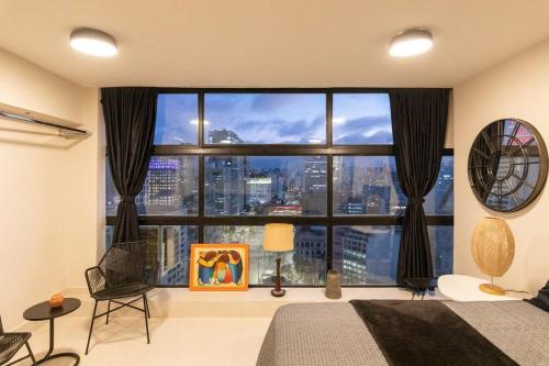 a bedroom with a large window with a city view at Mirante do Serjoca no Centro Histórico in Sao Paulo