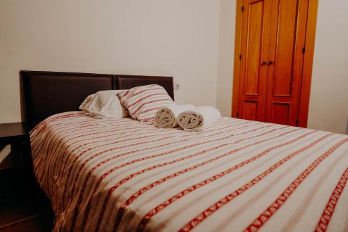 a bedroom with a bed with two towels on it at Apartamentos Boabdil in Sierra Nevada
