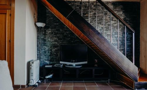 a television sitting on a dresser under a staircase at Apartamentos Boabdil in Sierra Nevada