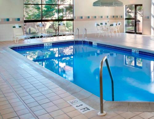 a swimming pool with blue water in a building at Sonesta Select Newark Christiana Mall in Newark