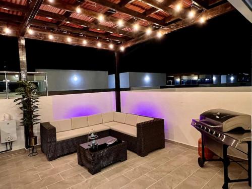 a living room with a couch and a table and a grill at Outstanding Pent House w/Jacuzzi in Santiago de los Caballeros