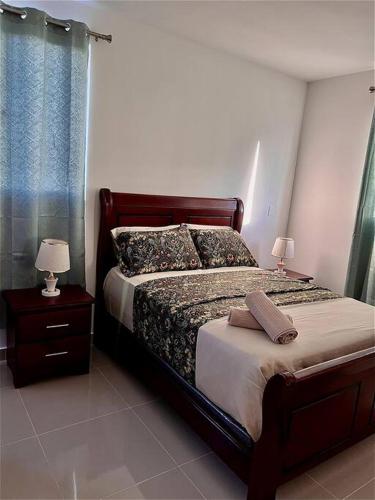 a bedroom with a bed and a nightstand with two lamps at Magnificent Pent House w/Jacuzzi in Santiago de los Caballeros