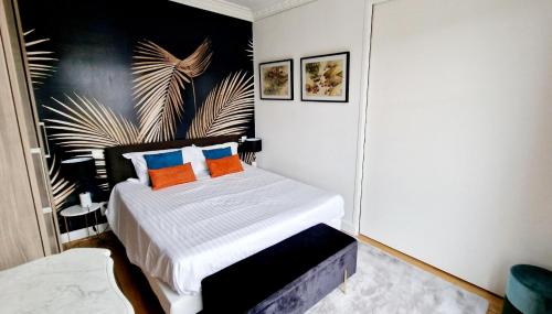 - une chambre dotée d'un lit avec des oreillers orange et bleu dans l'établissement Cocosmann, à Paris