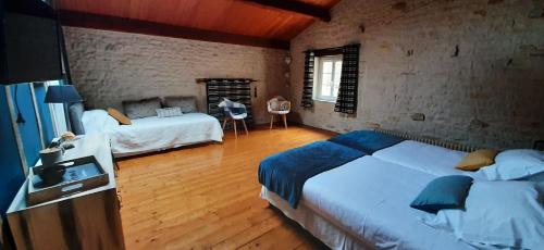 a large bedroom with two beds and a wooden floor at LA ROCHELLE LODGE in Sainte-Soulle