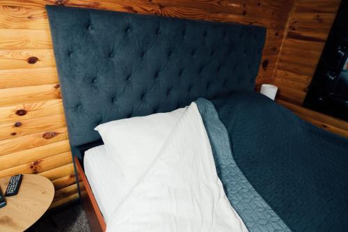 a bedroom with a bed with a blue headboard at Drive Club in Bondari