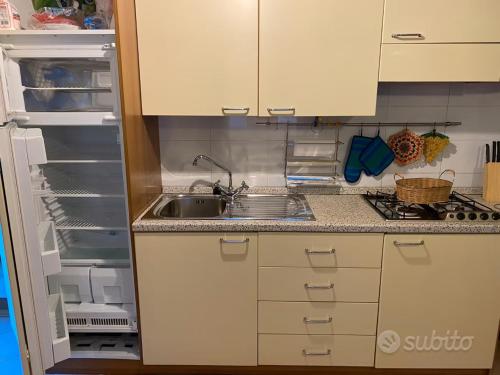 a kitchen with a sink and an open refrigerator at Sulle piste da sci in Abetone