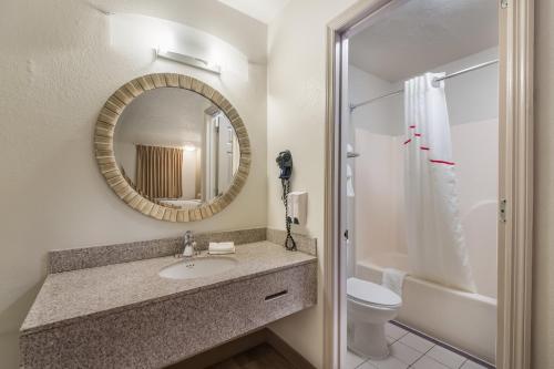 a bathroom with a sink and a mirror and a toilet at Red Roof Inn Crossville in Crossville