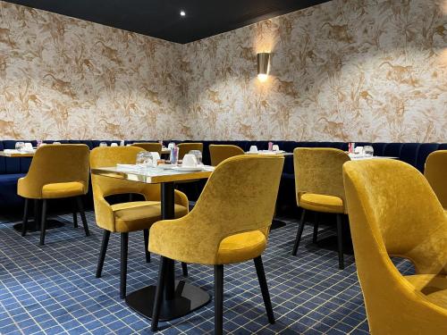 une salle à manger avec des tables et des chaises jaunes dans l'établissement Le Pergolèse Paris Champs Elysées, à Paris
