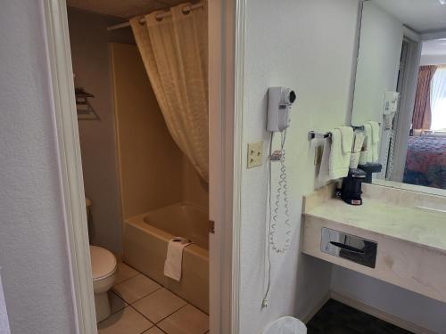 ein Bad mit WC und ein Telefon an der Wand in der Unterkunft Blue Ribbon Inn and Suites in Sallisaw