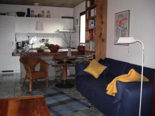 sala de estar con sofá azul y cocina en Casa Cresmino en Cavigliano