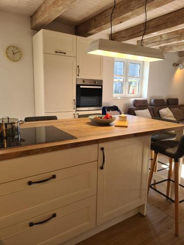 a kitchen with a counter with a sink and a table at Ostseenahes Ferienhaus mit 3 Schlafzimmern und großem Naturgarten in Nienhagen