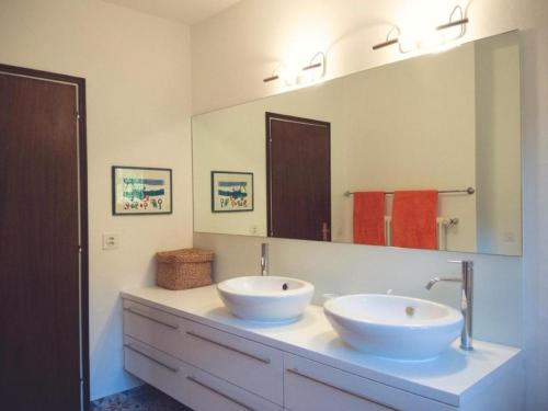 ein Badezimmer mit zwei Waschbecken und einem großen Spiegel in der Unterkunft Casa Nespole, Familiennest mit Seesicht in Minusio