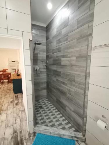 a shower in a bathroom with a tile wall at 34 Hornbill Street in St Lucia