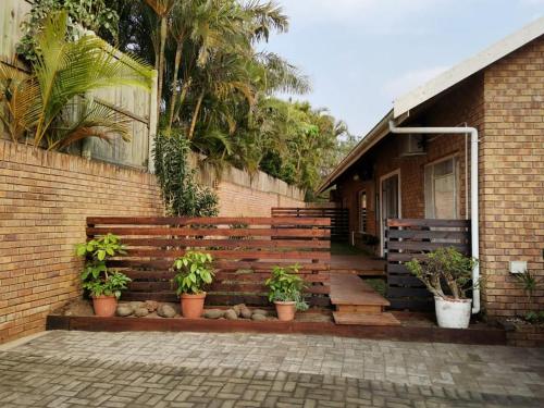 a house with a wooden fence and potted plants at 34 Hornbill Street in St Lucia