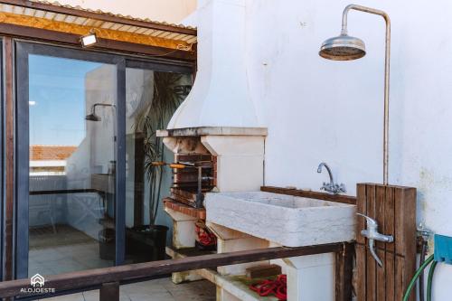 uma cozinha com um lavatório e uma janela em Casa da Torre - BBQ and Terrace em Santa Cruz