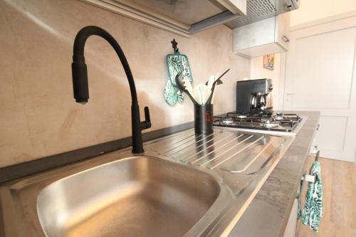 a kitchen sink with a faucet in a kitchen at Nora's House in Siena