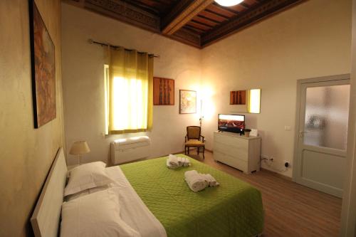 1 dormitorio con 1 cama verde y TV en Nora's House, en Siena