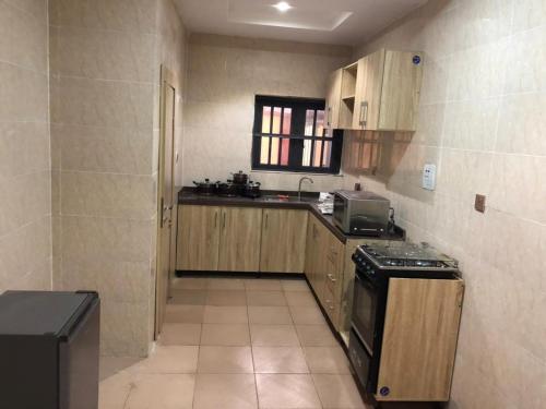 a small kitchen with a stove and a sink at Montrose Gardens in Lagos