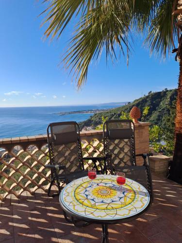 a table and two chairs sitting on a patio with the ocean at Villa kate in Taormina