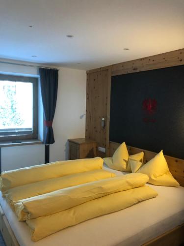 a bedroom with a large bed with yellow pillows at Gästehaus Wieshof in Vent