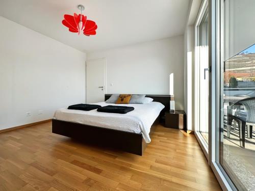 a bedroom with a bed and a large window at Aux Bons Matins de Gégé in Grimisuat