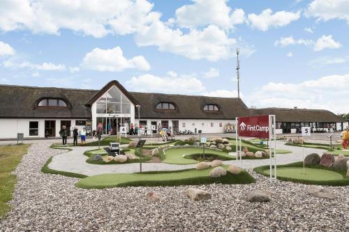 a building with a golf course in front of it at First Camp Klim Strand - Nordvestkysten in Fjerritslev