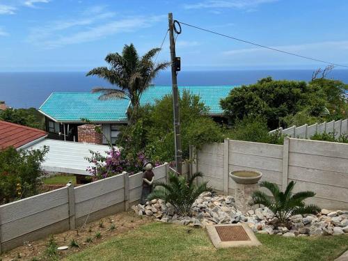 a fence in front of a house with the ocean at Tulip On The Bay in Mossel Bay