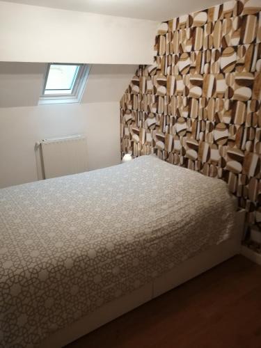 a bedroom with a bed with a wooden wall at Sainte Cécile in Boulogne-sur-Mer