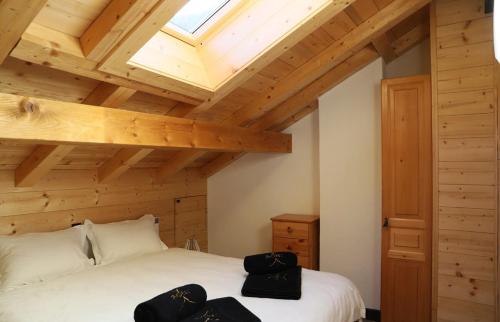 1 dormitorio con cama blanca y techo de madera en Cosy&star, en Salvan