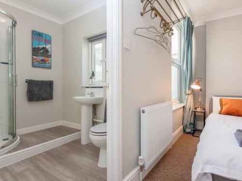 a white bathroom with a toilet and a sink at 2TheVilla - Great views, 3 bedrooms, parking, central location in Ilfracombe