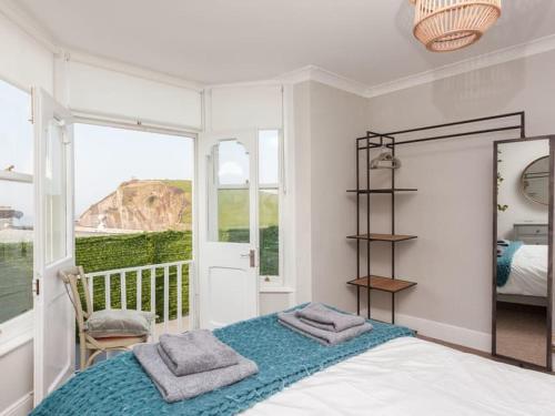 a bedroom with a bed with two towels on it at 2TheVilla - Great views, 3 bedrooms, parking, central location in Ilfracombe