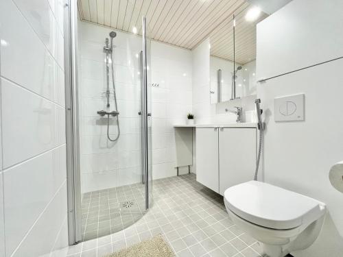 a white bathroom with a shower and a toilet at Tammer Huoneistot - City Suite 4 - Perfect Location & Great Amenities in Tampere