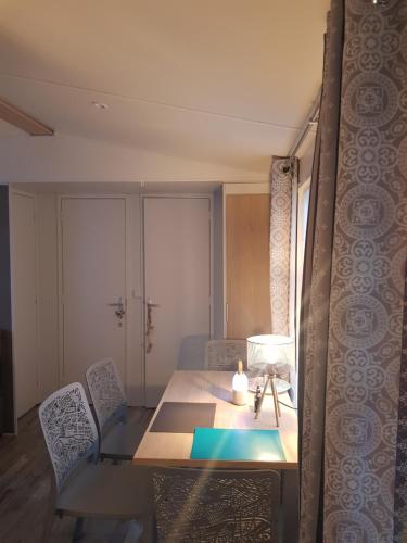 mesa de comedor con lámpara y sillas en Mobile-home Bonne -Anse Plage en Les Mathes