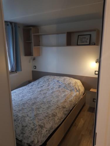 ein Schlafzimmer mit einem Bett in einem kleinen Zimmer in der Unterkunft Mobile-home Bonne -Anse Plage in Les Mathes