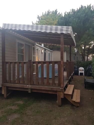 une grande terrasse avec un auvent sur une maison dans l'établissement Mobile-home Bonne -Anse Plage, aux Mathes
