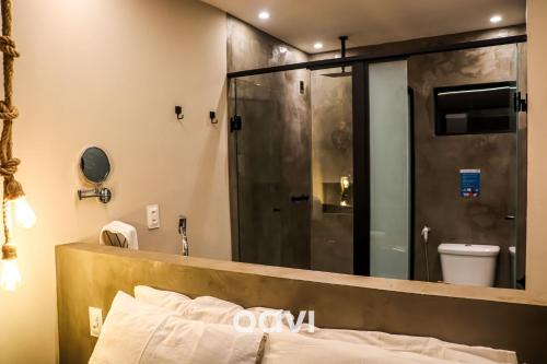 La salle de bains est pourvue d'une douche et d'un grand miroir. dans l'établissement Pousada Marajoara - Quarto à Vista, à Pipa