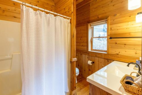 a bathroom with a white shower curtain and a sink at Brother Bear Hollow in Stecoah