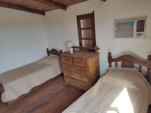 um quarto com 2 camas e uma cómoda em madeira em Quinta en Alvear em General Alvear