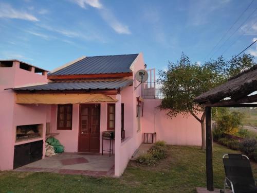 une maison rose avec un toit noir dans l'établissement Quinta en Alvear, à General Alvear