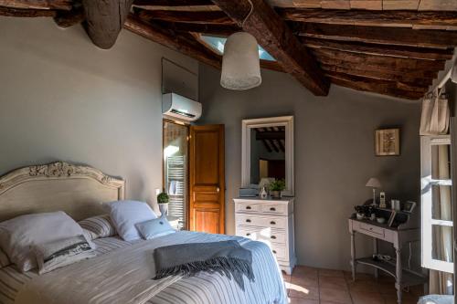 una camera con letto, cassettiera e specchio di Made in Lourmarin a Lourmarin