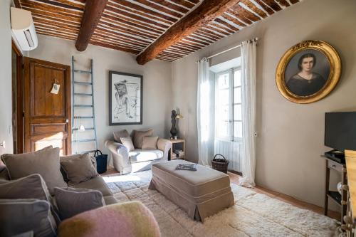 a living room with a couch and a mirror at Made in Lourmarin in Lourmarin
