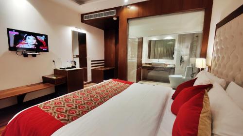 a bedroom with a large bed and a television at Royale Retreat Hotel & Spa Near Mall Road in Shimla