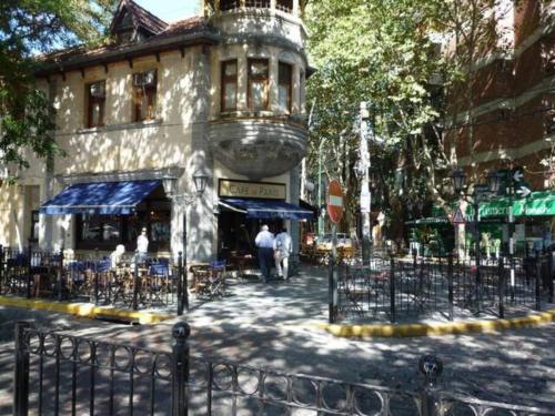 維森特洛佩斯的住宿－PH cerca Río de la Plata, bares y cafes，城市街道上一座配有桌椅的建筑