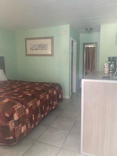 a hotel room with a bed and a desk at Royal Canadian Motel in Wildwood