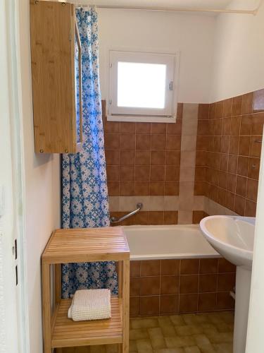 ein Badezimmer mit einer Badewanne und einem Waschbecken in der Unterkunft Camargue Village Sun and Beach #2 in Le Grau-du-Roi