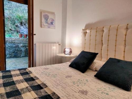 een slaapkamer met een groot bed en een raam bij El Mirador de La Hayuela, a 7 min de Comillas in Comillas