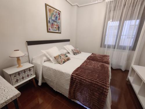 Un dormitorio blanco con una cama y una ventana. en Piso Bilbao San Mamés, en Bilbao