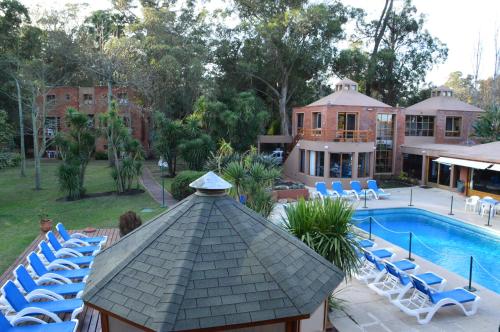 a group of chairs and a gazebo next to a pool at Rincon del Este Resort in Punta del Este